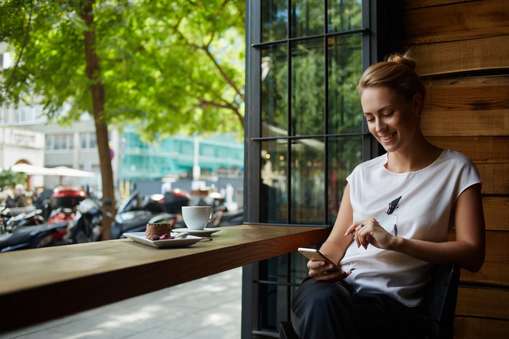 Happy woman using mobile device outside